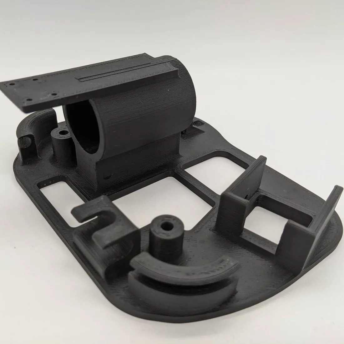 A gray 3D-printed mounting base with a circular seat, side brackets, and bolt holes.